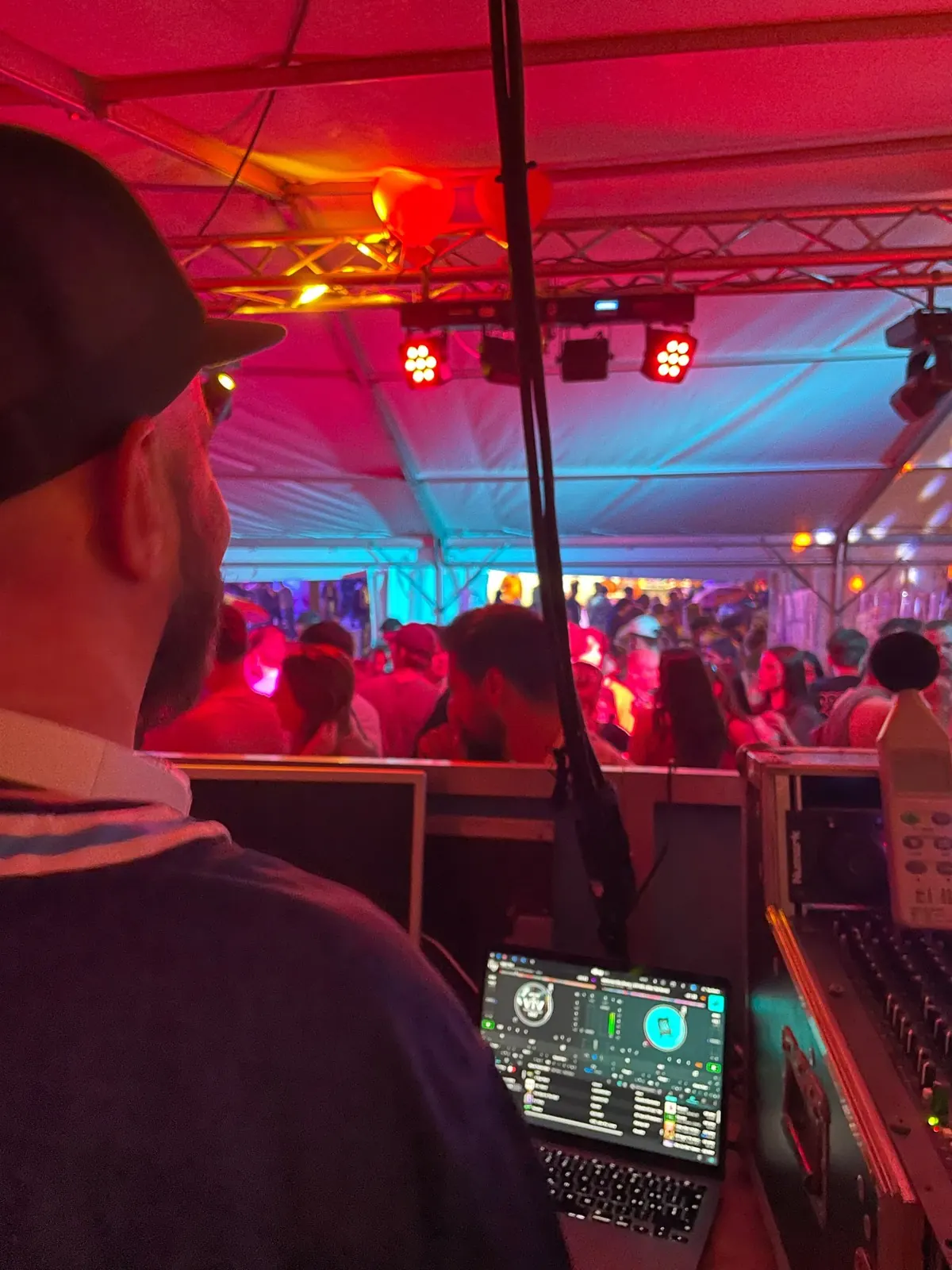 Blick vom DJ-Pult in ein Festzelt in rotem Licht