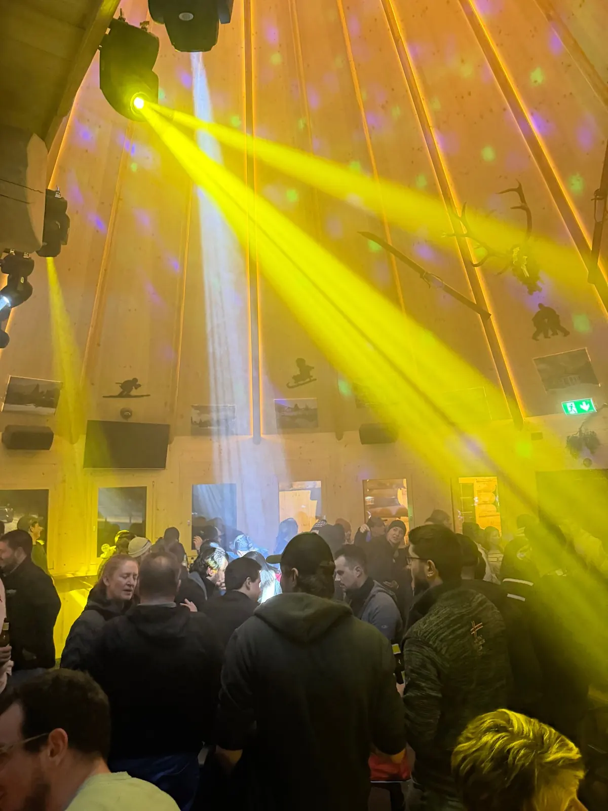 Gelbe Lichtkegel über einer vollen Tanzfläche